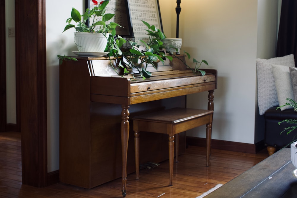 Piano droit en bois clair adossé à un mur, tabouret devant